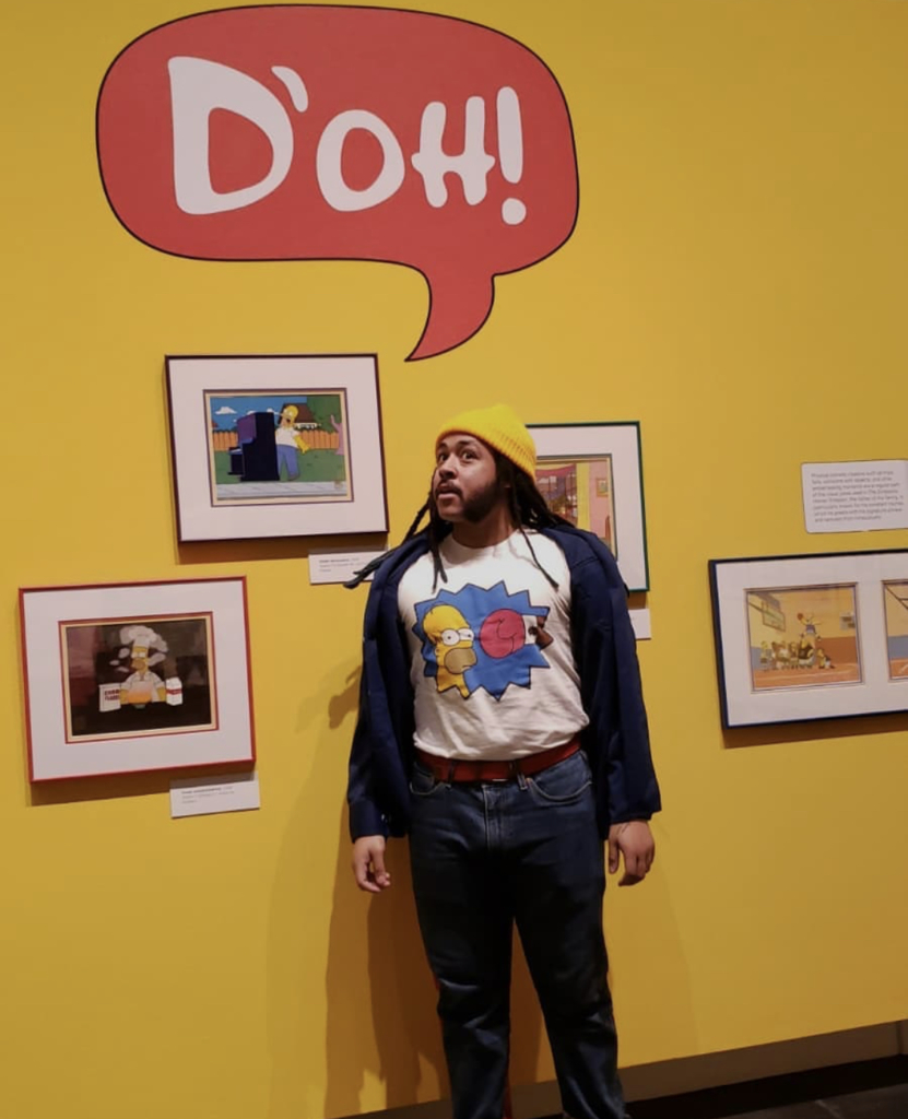 A visitor stands in front of animation cels on view in Bart at TAM: Animating America's Favorite Family. 