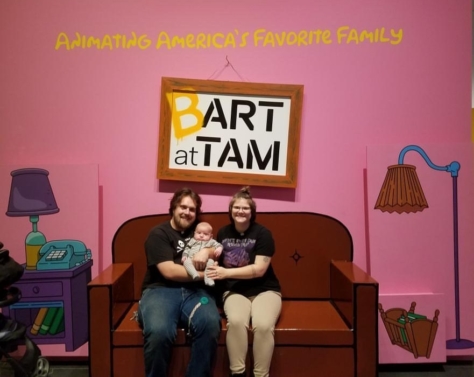 Three people sit on the couch in Bart at TAM: Animating America's Favorite Family.