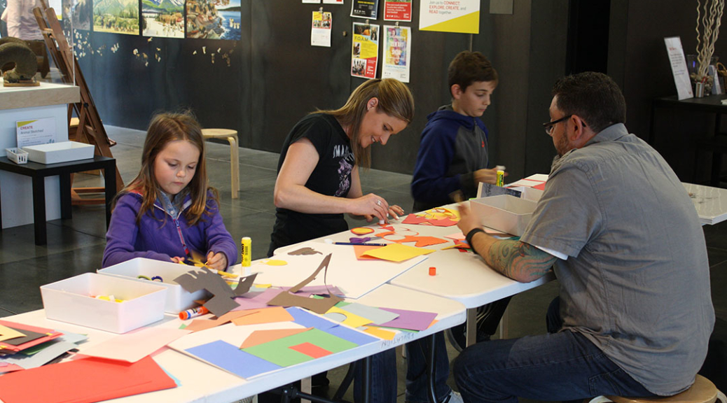 Two adults and two children create art in the museum's art studio.