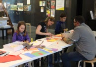 Two adults and two children create art in the museum's art studio.