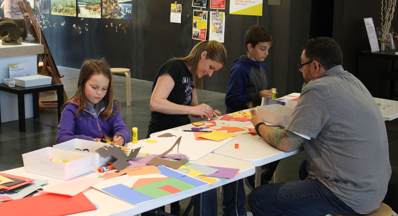 Two adults and two children create art in the museum's art studio.