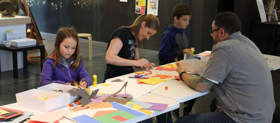 Two adults and two children create art in the museum's art studio.