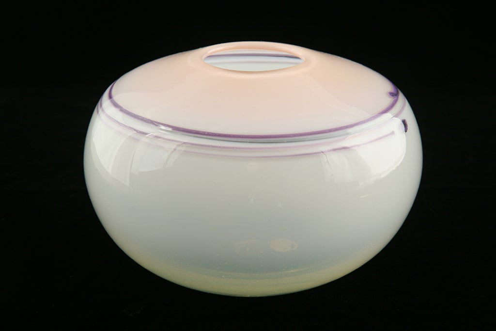 Glass vessel with a white bottom and pink top. Purple lines circle the shoulder