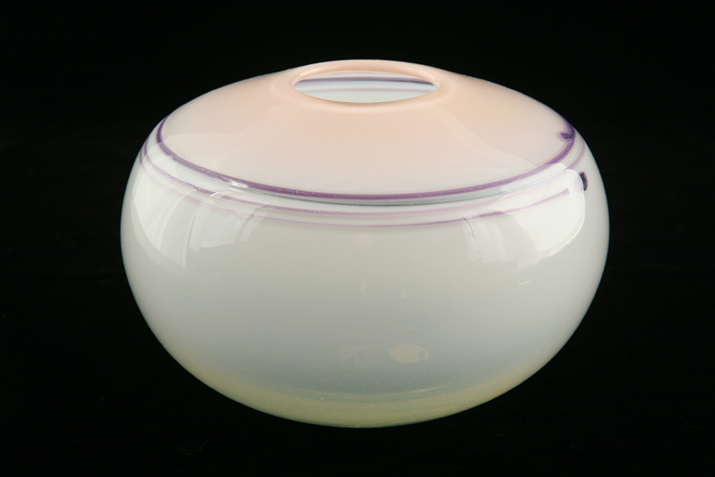 Glass vessel with a white bottom and pink top. Purple lines circle the shoulder