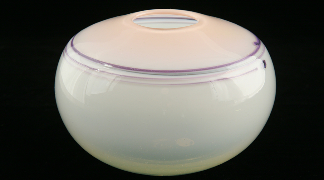 Glass vessel with a white bottom and pink top. Purple lines circle the shoulder