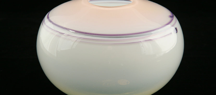 Glass vessel with a white bottom and pink top. Purple lines circle the shoulder