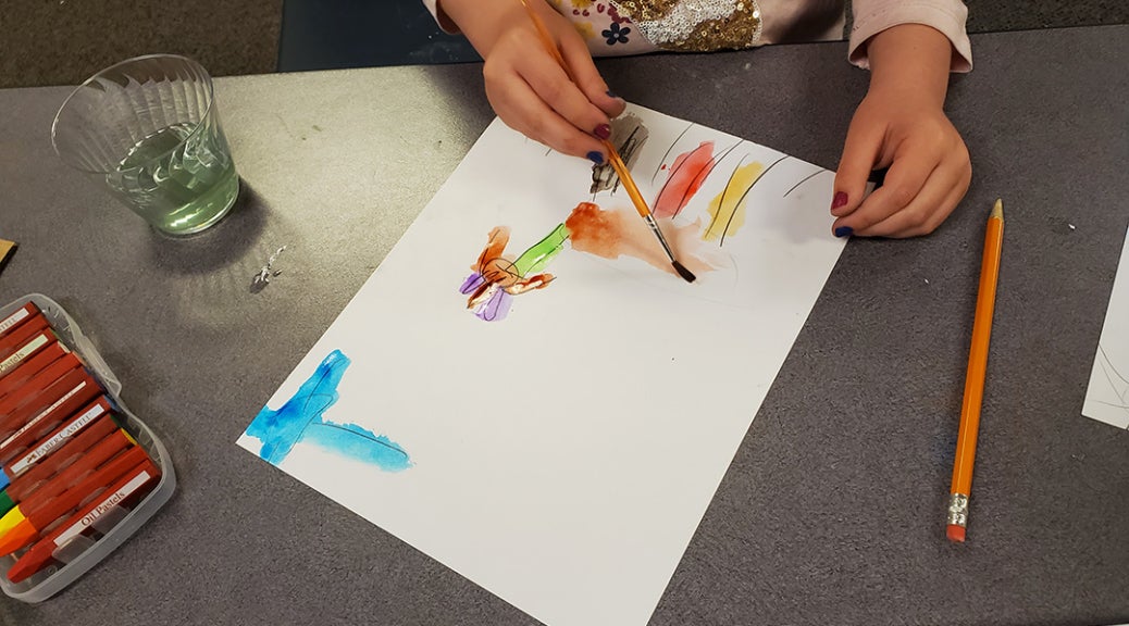 Child completes a painting using watercolors.