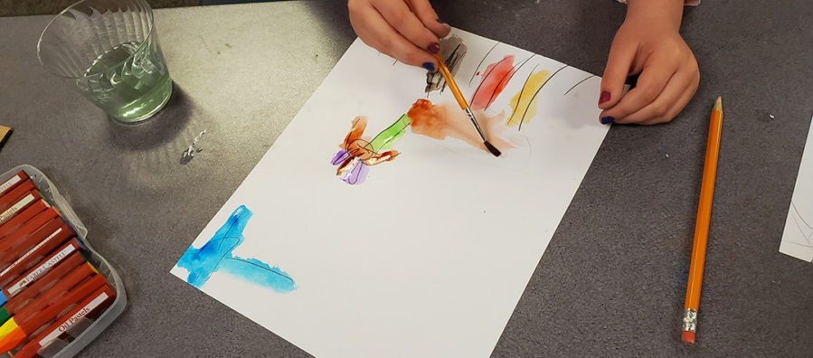 Child completes a painting using watercolors.