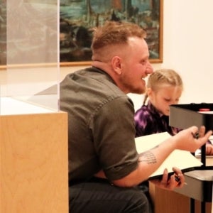 META Jamie Cook works with students in the gallery at TAM.
