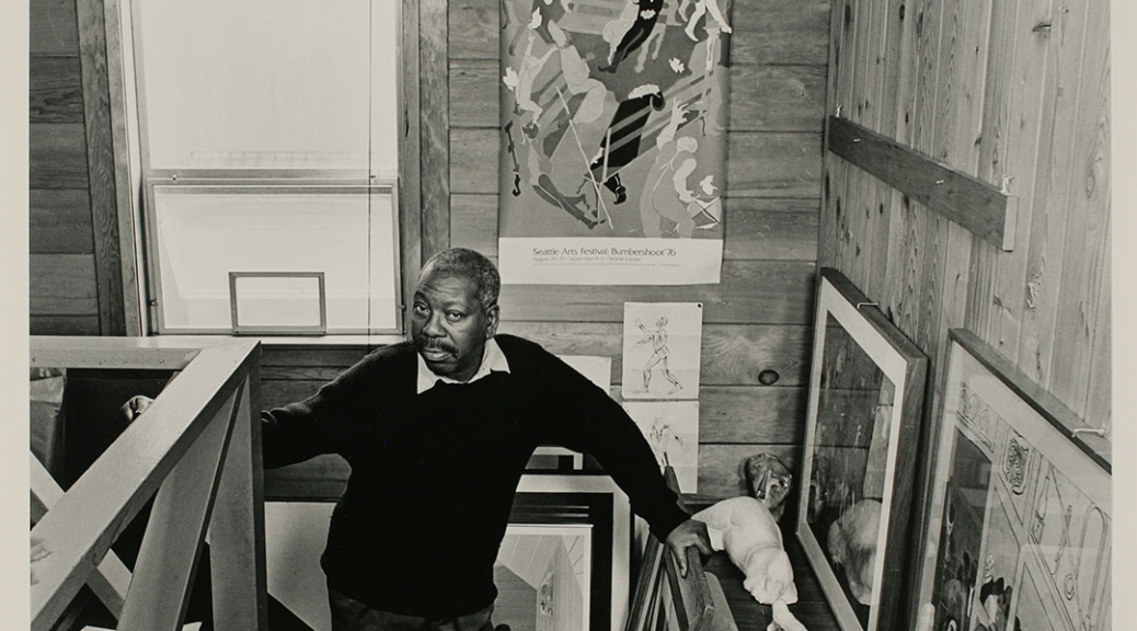 Black and white portrait of the artist, Jacob Lawrence standing on the stairs up to his loft studio.