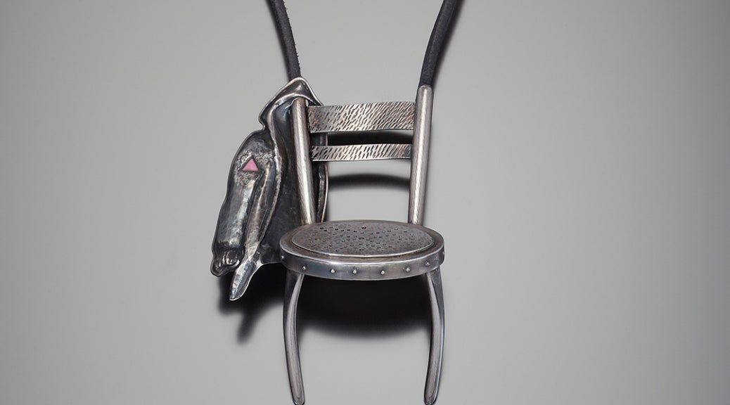 Chair with jacket hanging on proper right side of chair back.