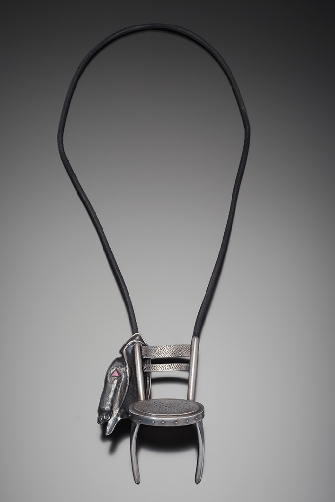 Chair with jacket hanging on proper right side of chair back.