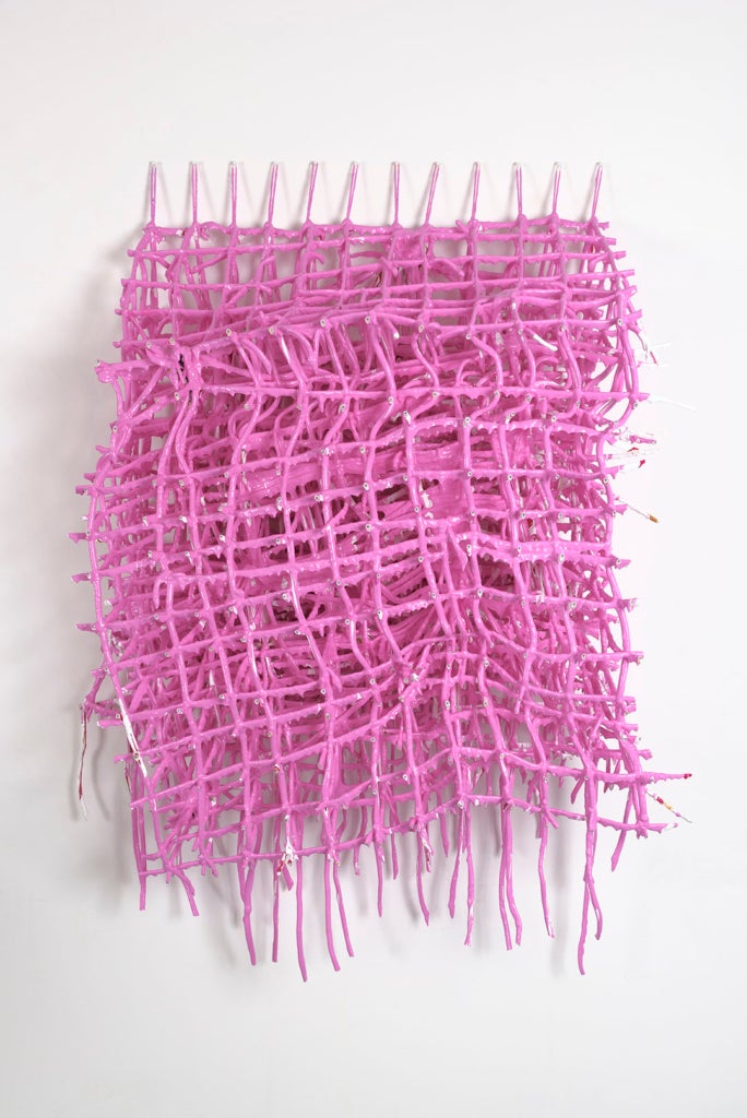 A three-dimensional grid of string covered in pink paint. The weight of the paint has deformed the string grid.