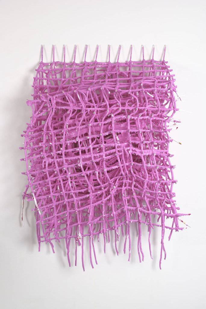 A three-dimensional grid of string covered in pink paint. The weight of the paint has deformed the string grid.