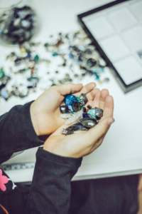 Pair of hands cupping a variety of gemstones.