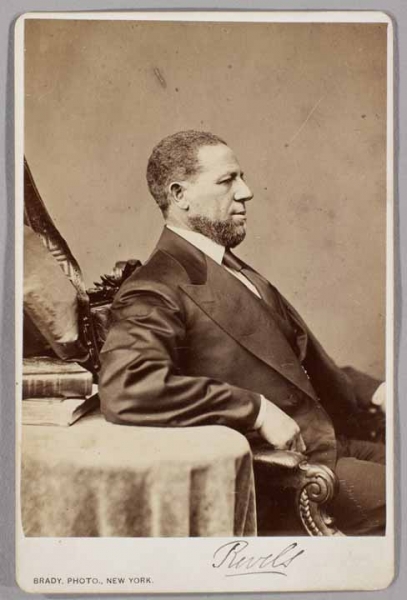 Black and white photograph of Senator Hiram Rhodes Revels seated in profile.