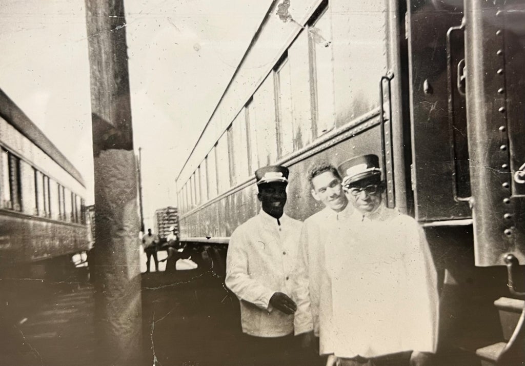 Photo of three Pullman Porters posed in front of a train.