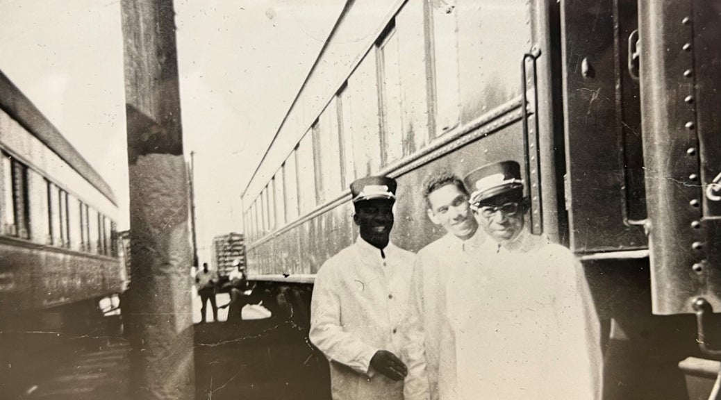 Photo of three Pullman Porters posed in front of a train.