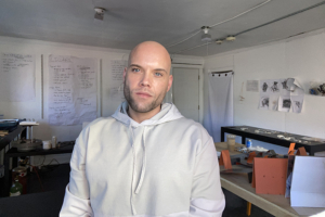 Photograph of jewelry artist Seth Papac in their studio.