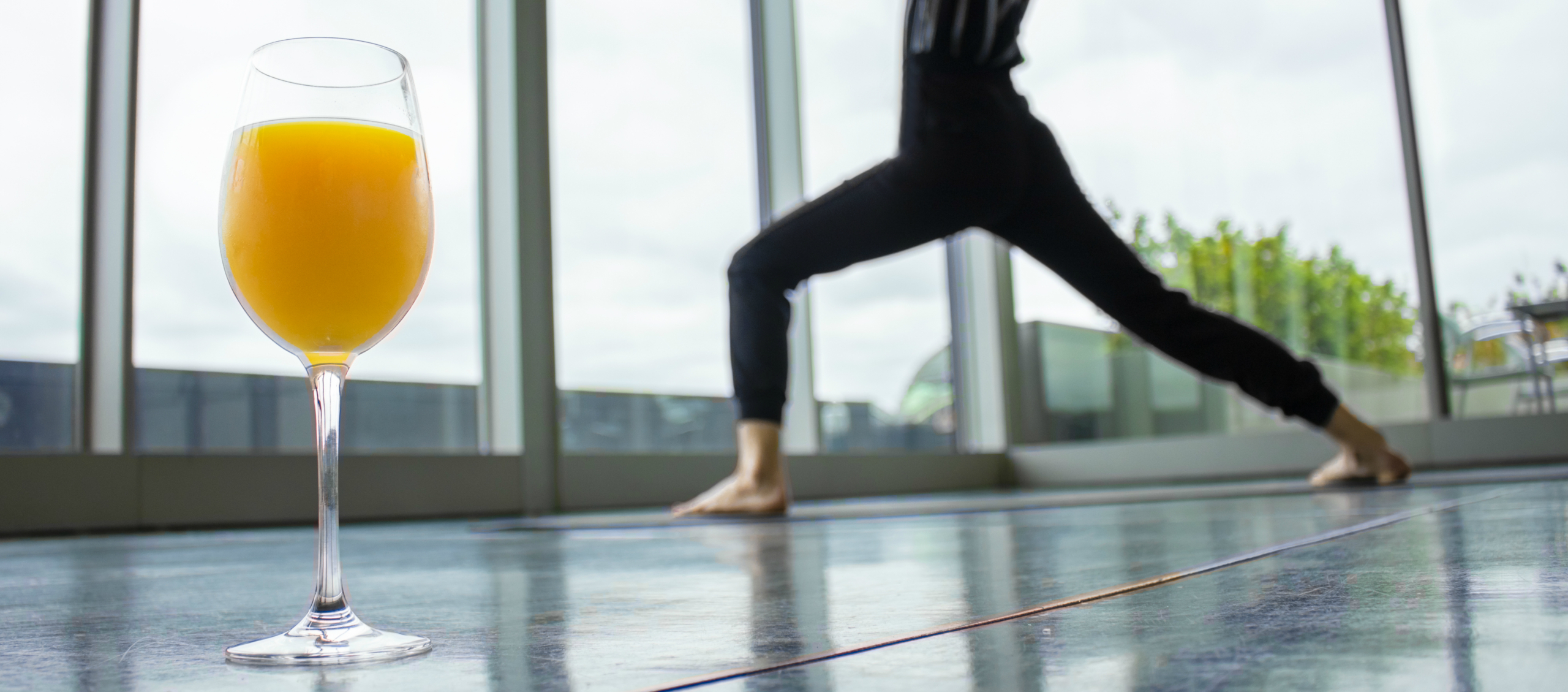 Woman doing yoga with glass of mimosa