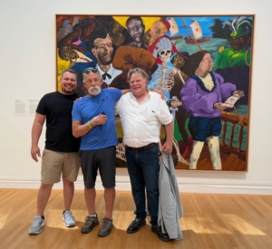 An image of Cooper, Alex, and Dennett Colescott standing in front of a Robert Colescott art work.